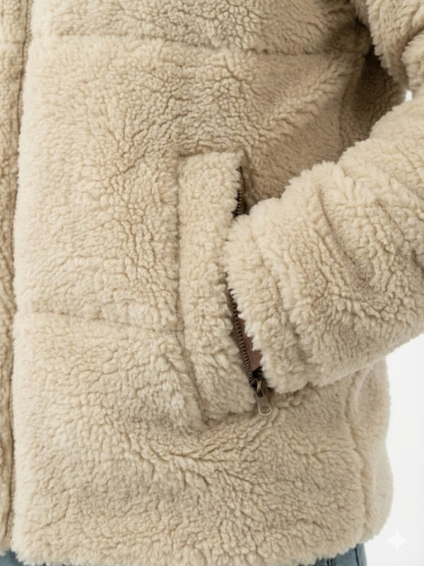 Close-up of a beige sherpa jacket with a focus on texture and stitching.