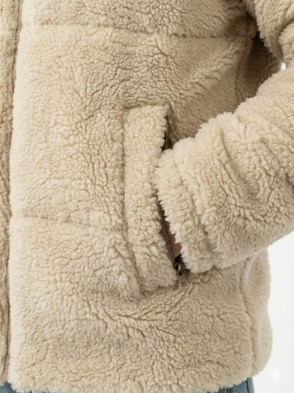 Close-up of a beige sherpa jacket with a focus on texture and stitching.