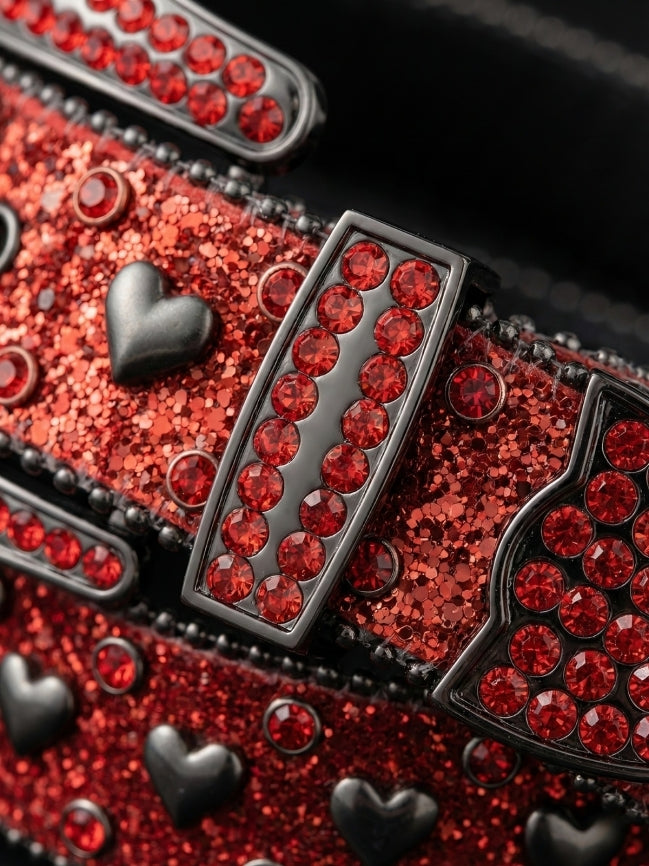 Close-up of a red glittery belt with black heart designs and red gemstones.