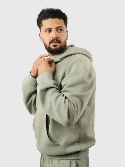 Man wearing a light green hoodie on a white background