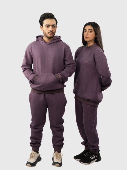 Two people wearing matching purple sweatsuits on a white background