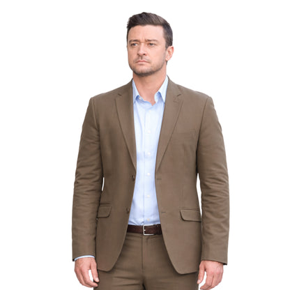 Man wearing a brown suit jacket over a light blue shirt on a white background