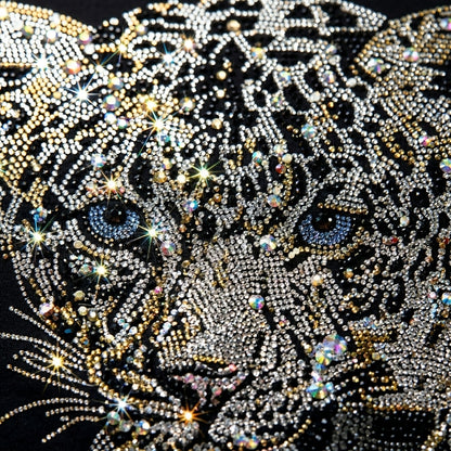 Leopard face design made with rhinestones on a black background