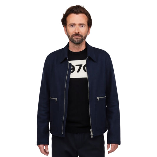 Man wearing a navy jacket over a black t-shirt with white text on a white background