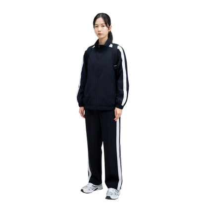 Person wearing a black tracksuit with white stripes on a white background