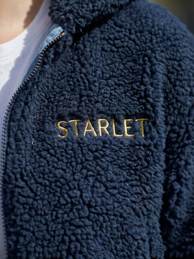 Navy blue fleece jacket with 'STARLET' embroidery on a blurred background