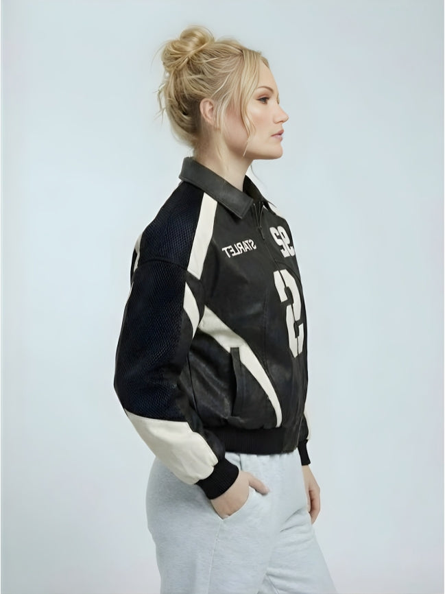 Woman wearing a black and white jacket with visible branding on a light gray background