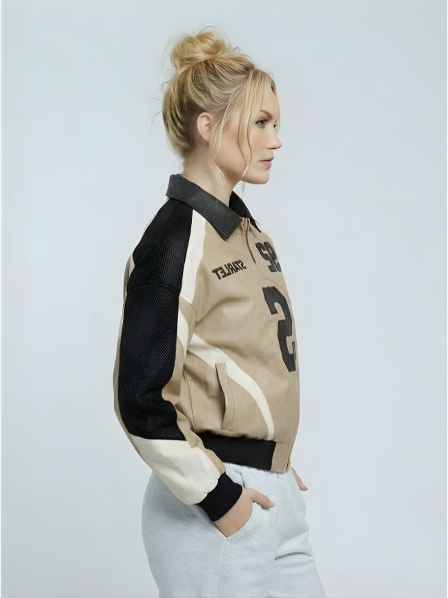 Woman wearing a black, beige, and white jacket on a light gray background