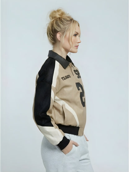 Woman wearing a black, beige, and white jacket on a light gray background