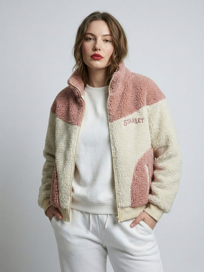 Woman wearing a two-tone fleece jacket with 'Starlet' branding on a plain background