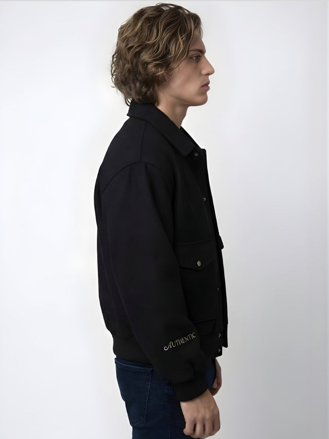 Person wearing a black jacket with 'Authentic' branding on a white background
