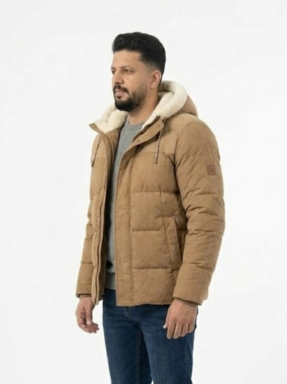 Man wearing a brown puffer jacket with a white hood on a light gray background