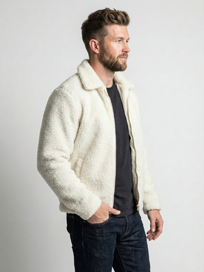 Man wearing a cream sherpa jacket against a plain background
