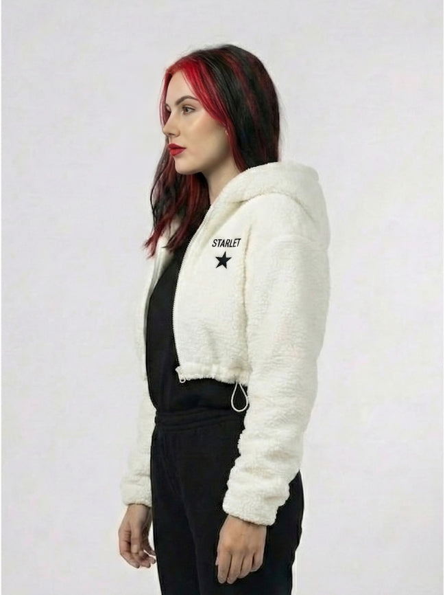 Woman wearing a white fluffy jacket with 'Starlet' branding on a plain background