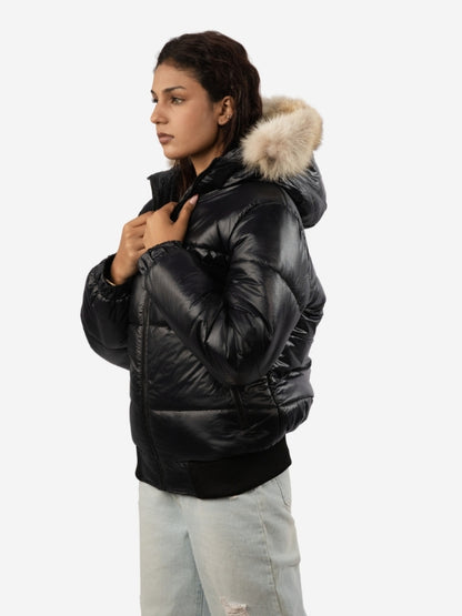 Woman wearing a black puffer jacket with fur hood on a white background