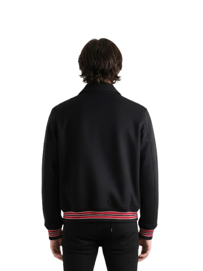 Person wearing a black jacket with red and white stripes on a white background