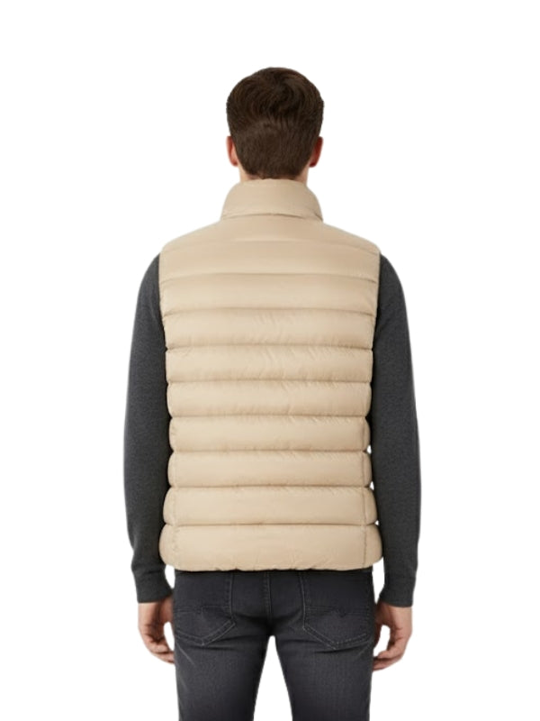 Man wearing a beige puffer vest on a white background
