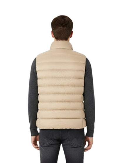 Man wearing a beige puffer vest on a white background