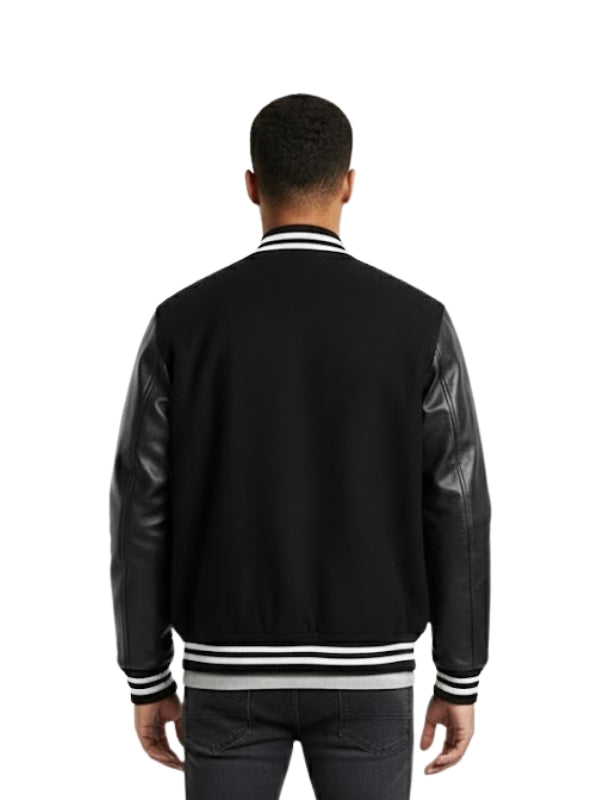 Person wearing a black varsity jacket with leather sleeves on a white background