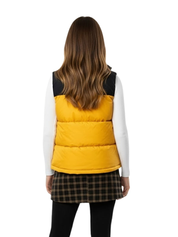 Person wearing a yellow puffer vest over a plaid skirt on a white background