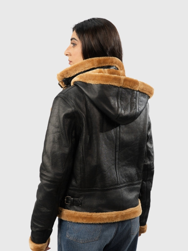 Person wearing a black leather jacket with brown fur lining on a white background