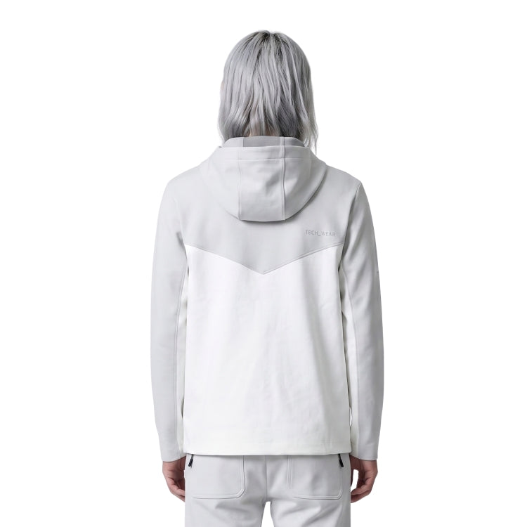 Person wearing a light gray hoodie with a subtle design on the back against a white background