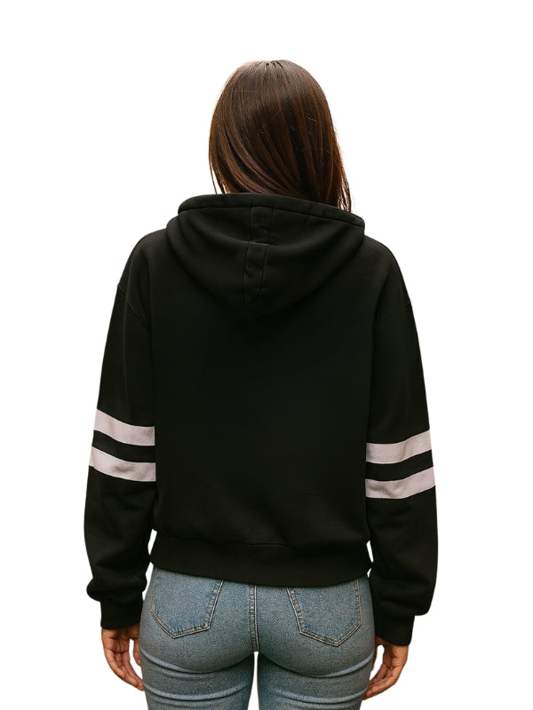 Person wearing a black hoodie with white stripes on sleeves against a white background