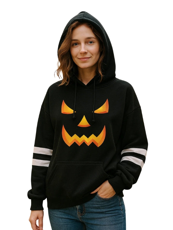 Person wearing a black hoodie with a jack-o'-lantern face design on a white background