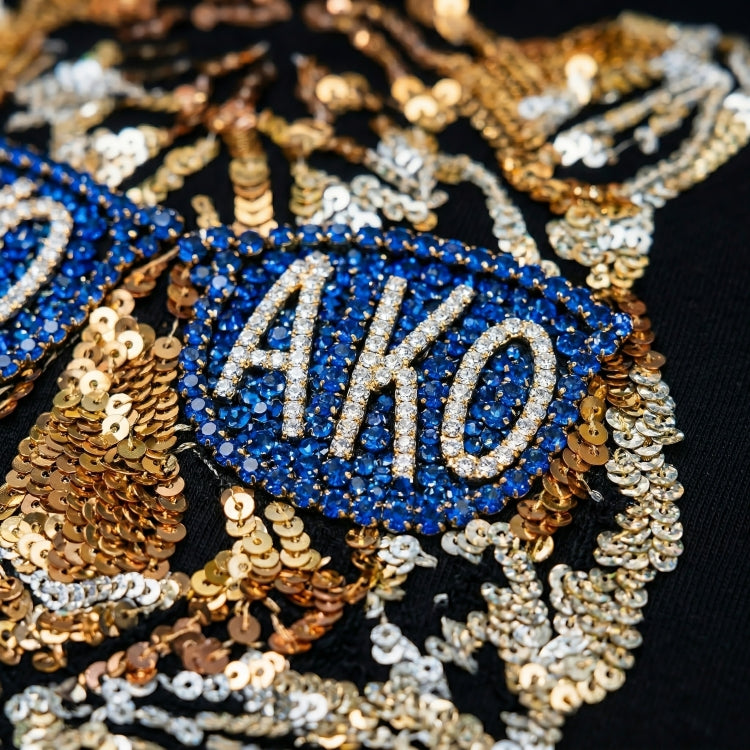 Decorative patch with 'AKO' text surrounded by blue and gold sequins on a black background