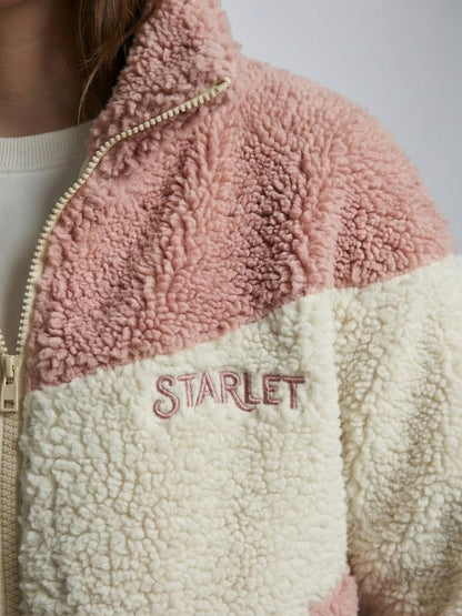 Close-up of a pink and beige sherpa jacket with 'STARLET' branding.