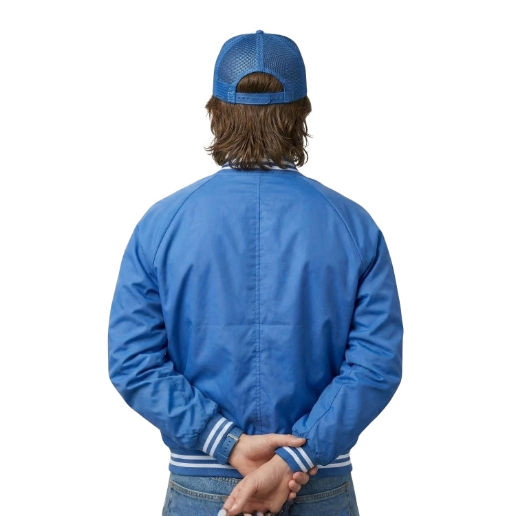 Person wearing a blue jacket and cap from behind on a white background