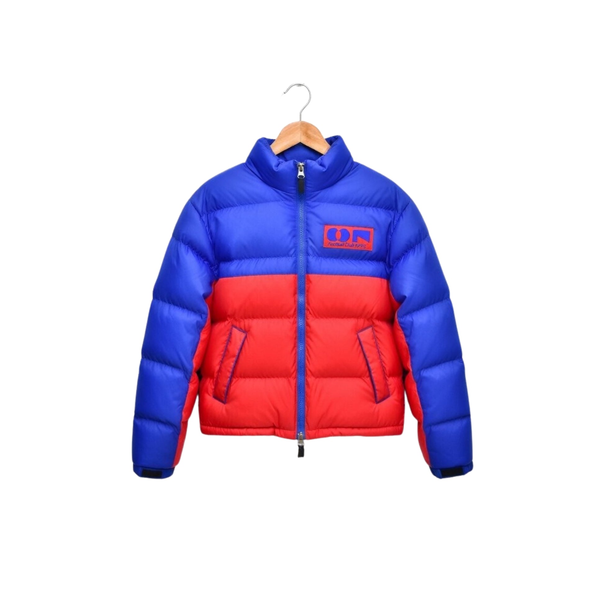 Blue and red puffer jacket on a hanger against a white background