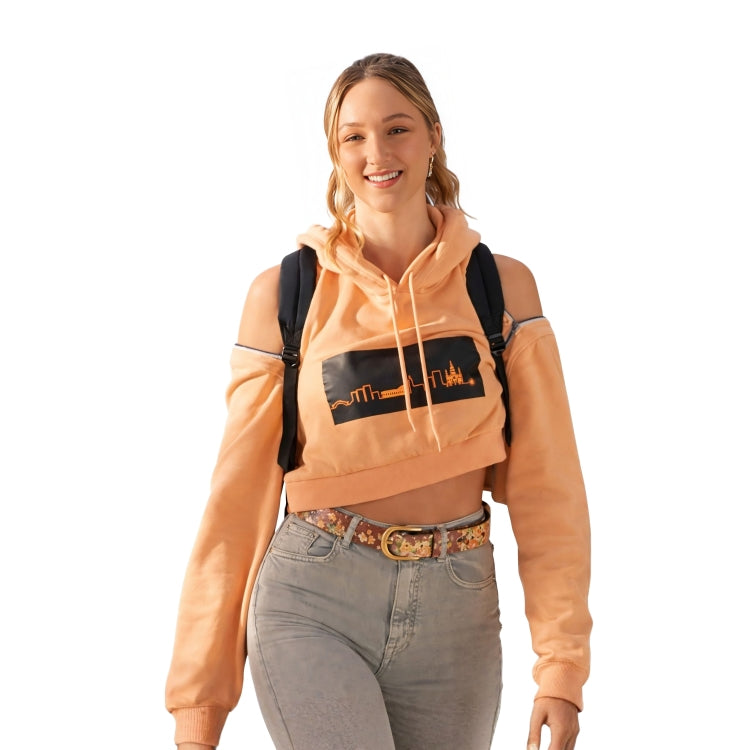 Woman wearing a peach hoodie with a graphic design, gray jeans, and a black backpack on a white background