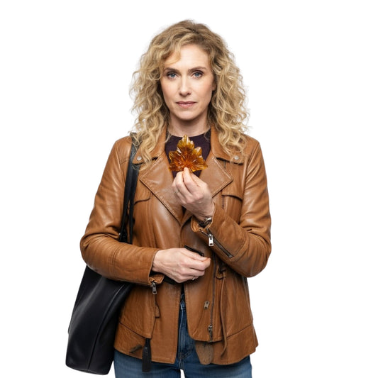 Woman in a brown leather jacket holding an autumn leaf against a white background