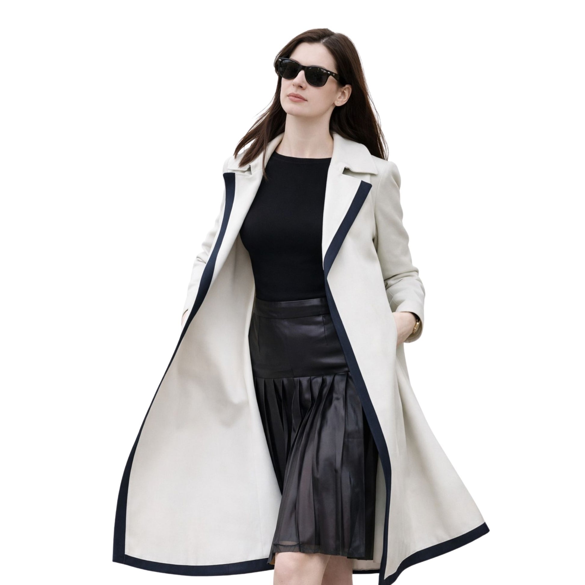 Woman wearing a long white coat with black trim on a white background