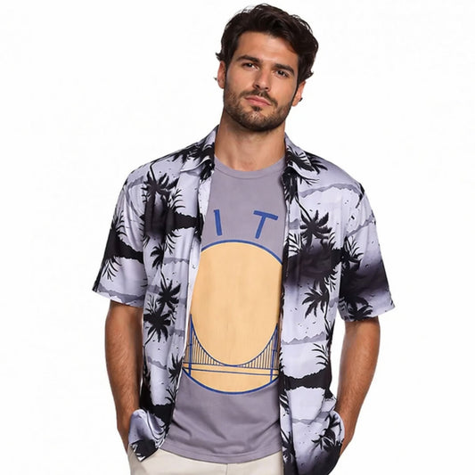 Man wearing a patterned shirt over a graphic t-shirt on a white background
