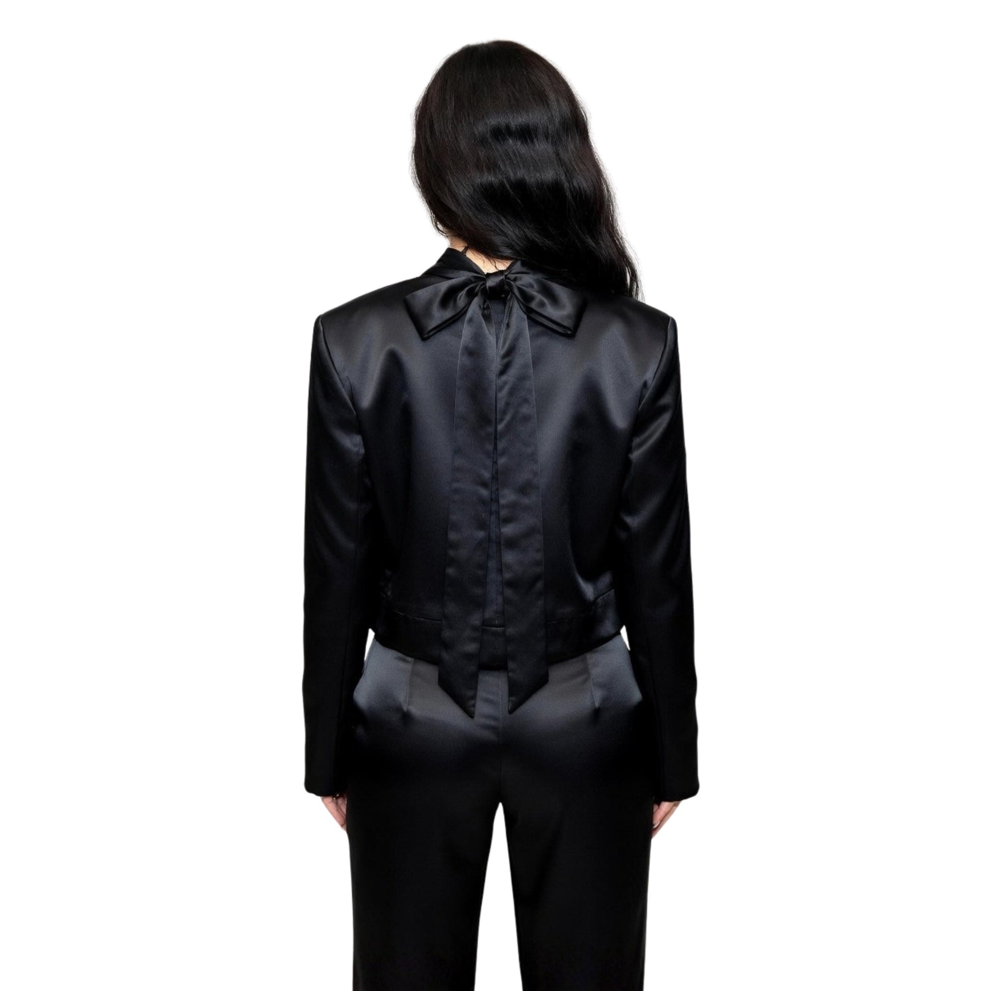 Person wearing a black satin outfit with a bow tie on a white background