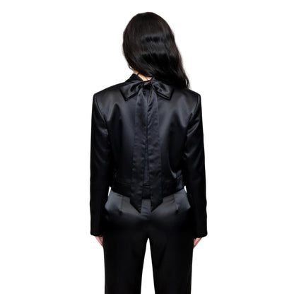 Person wearing a black satin outfit with a bow tie on a white background