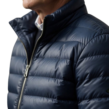 Close-up of a person wearing a navy blue puffer jacket on a white background