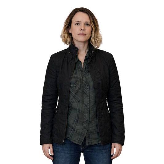 Woman wearing a black jacket over a plaid shirt on a white background