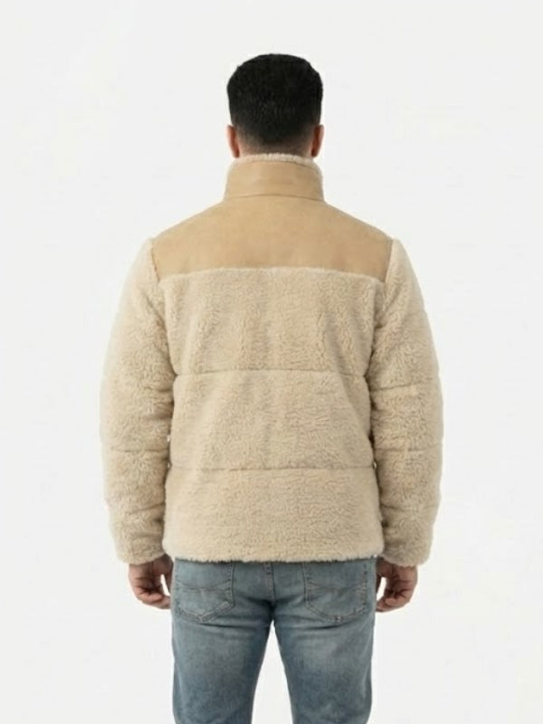 Person wearing a beige quilted jacket on a white background