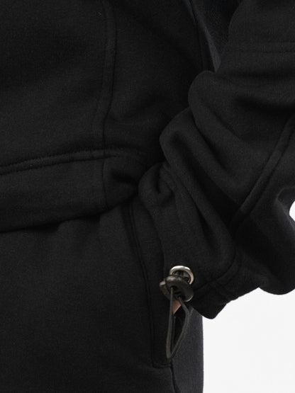 Close-up of a black coat with a button on a white background