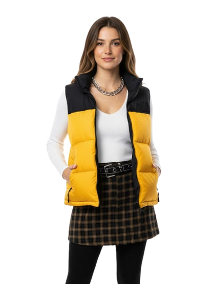 Woman wearing a yellow and black puffer vest on a white background