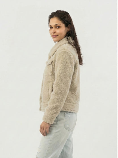 Woman wearing a beige sherpa jacket on a white background