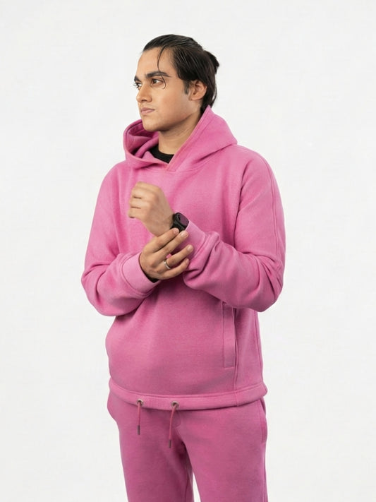 Person wearing a pink hoodie and pants on a white background