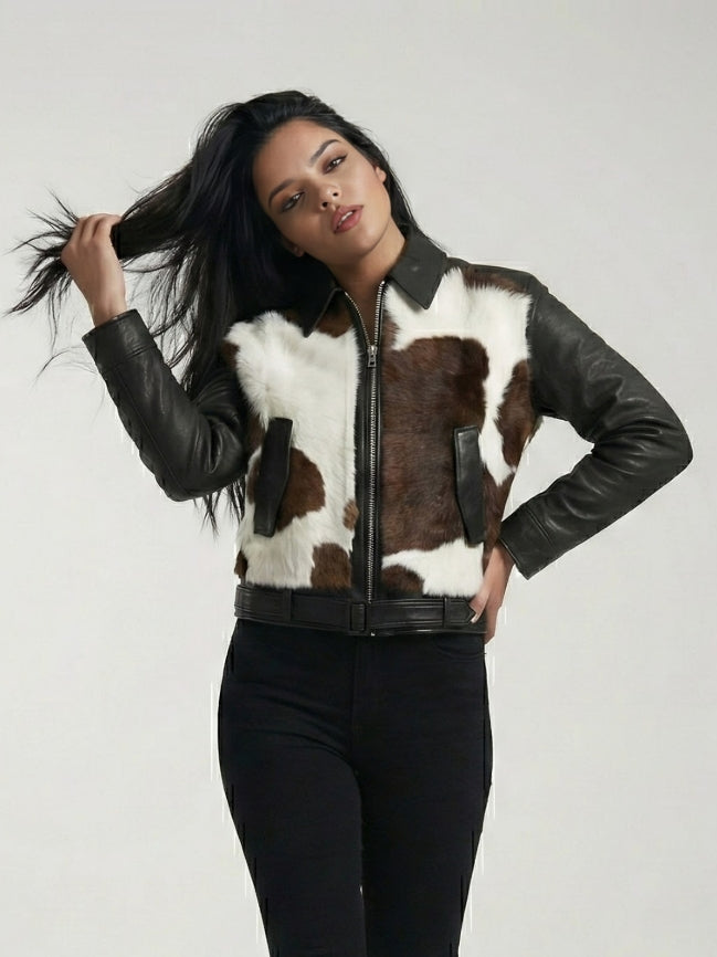 Woman wearing a cowhide leather jacket with black leather sleeves on a plain background