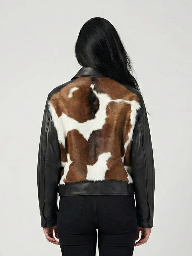 Person wearing a black leather jacket with a cowhide pattern on the back against a white background