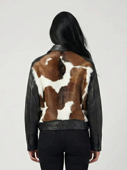 Person wearing a black leather jacket with a cowhide pattern on the back against a white background
