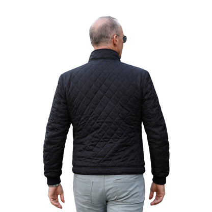 Man wearing a black quilted jacket on a white background
