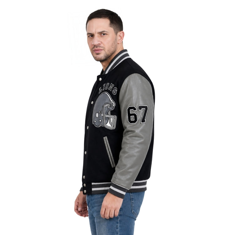 Man wearing a black and gray varsity jacket with letterman design on a white background
